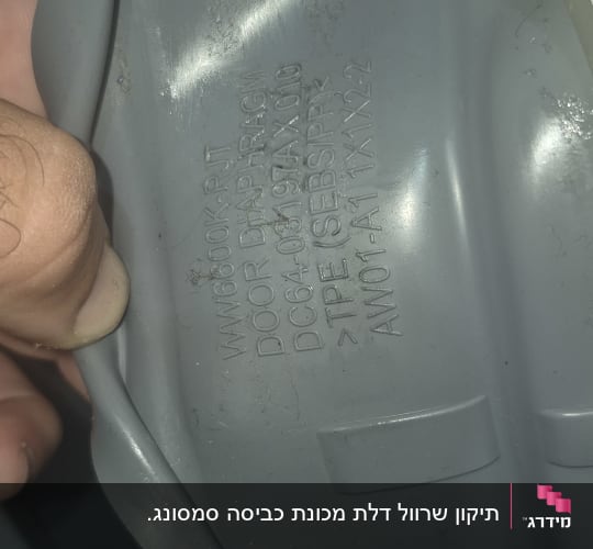 חלק פלסטיק עם כיתוב טכני, כנראה חלק ממכשיר חשמלי